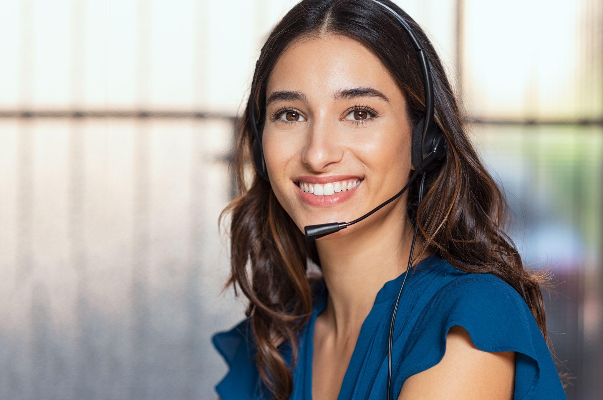 happy customer support phone operator at call center wearing headset