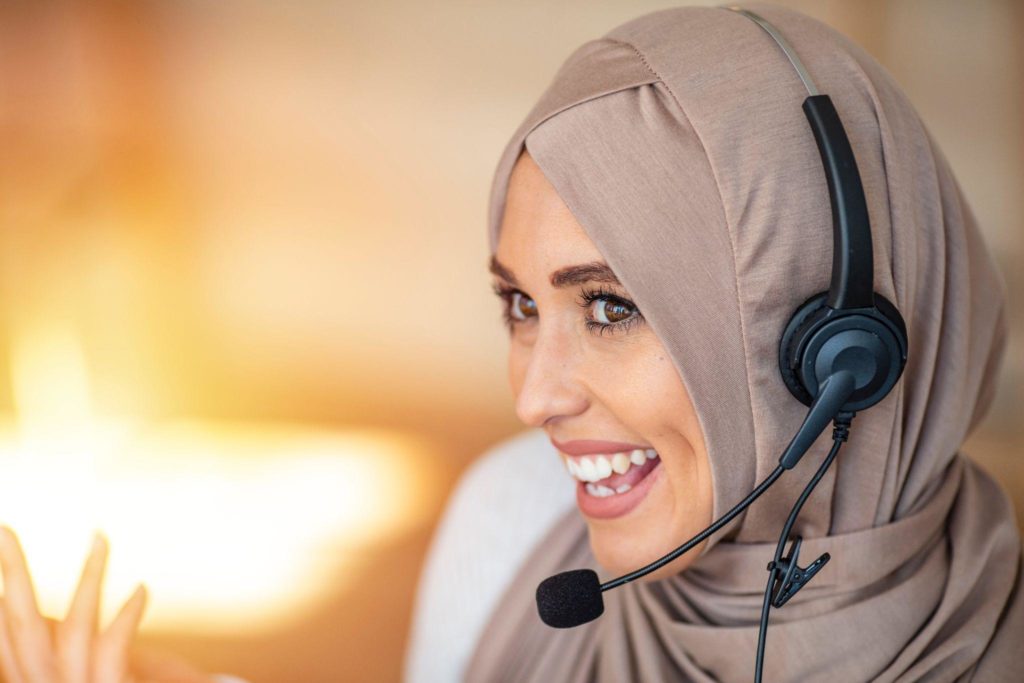 Muslim woman wearing microphone headset working as customer service operator