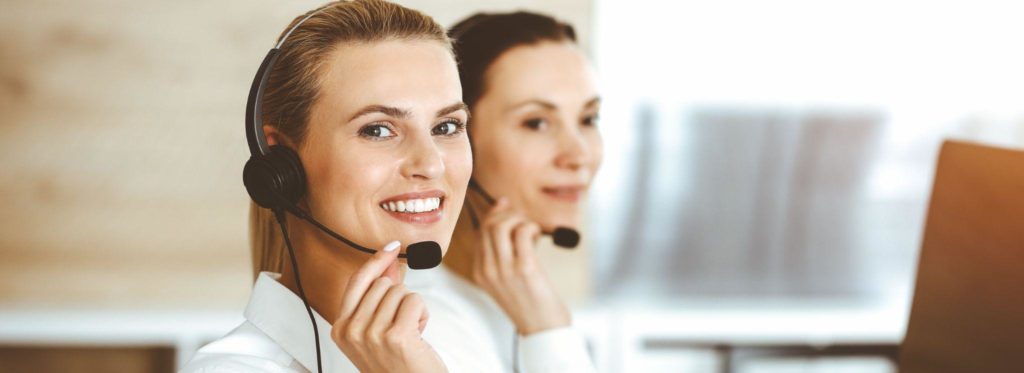 Female customer service representative is consulting clients online using headset