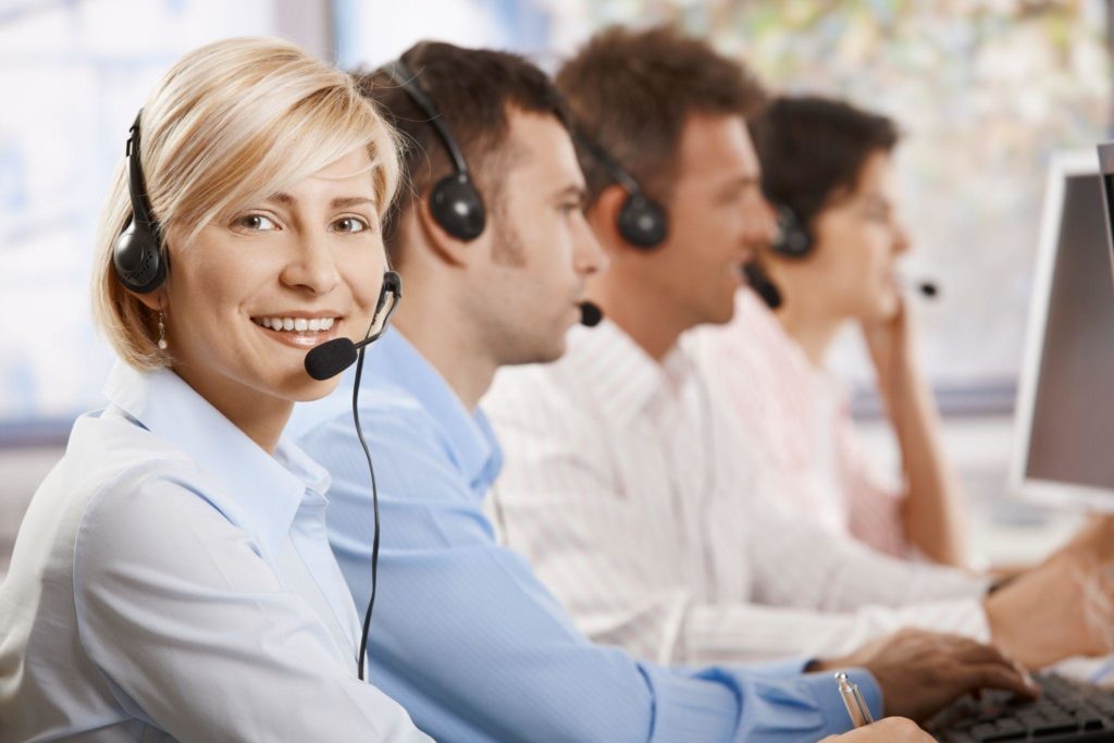 Happy female customer service operator recieving calls on headset